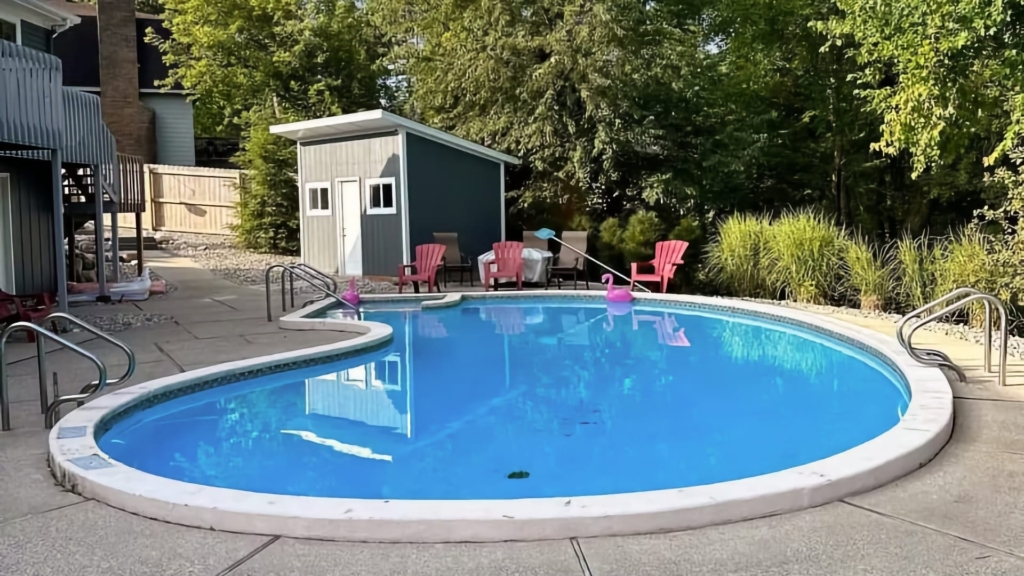 a kidney shaped swimming pool in a backyard.